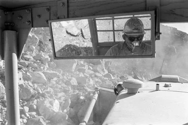 Heavy equipment operator in cab at open-pit copper mine, Morenci Mine, for Phelps Do...