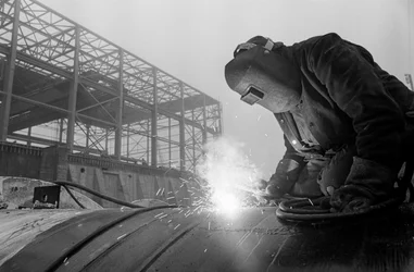 Welder uses acetylene torch to weld industrial pipes at construction site at Hanford operations