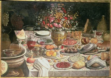 Still life of table laden with food, drink and a vase of flowers