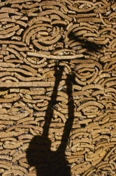 Shadow of man stacking cork for export from Morocco