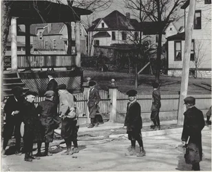 A Group of Boys in Winter Coats Standing on an Unidentified Street Either Before or After a School Day.