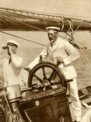 King George V at the wheel of his yacht, Britannia, during Cowes Regatta week