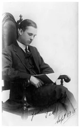 Man sitting in a chair reading a book, 1918
