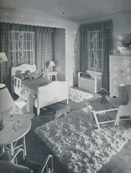 Nursery by W. & J. Sloane, with cream-coloured furniture and shaggy white rugs on a blue painted floor