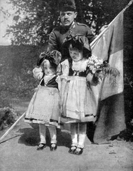 Young Alsatian children in traditional dress with a French soldier, World War I
