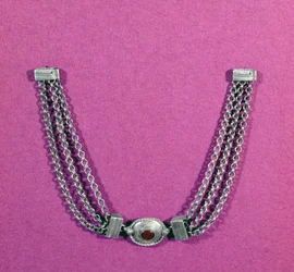 Silver necklace comprising a cornelian, in an oval setting edged with a cable moulding, suspended between two lengths of three chains fastened by a box-like clasp, found in Great Chesters, mid 1st to early 2nd century AD
