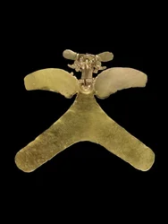 A Costa Rican gold avian pendant, the predatory bird cast with an openwork beak, grasping a small curly-tailed animal, c. 800-1200