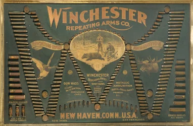 A Winchester Cartridge display board, with a comprehensive selection of metallic, brass and paper-case rifle and shot cartridges arranged in the form of an extended 