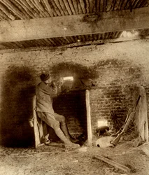 British Sniper lying in wait in a loop-holed stable