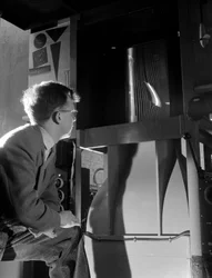 Engineer in wind tunnel with smoke tests under way on a small wing section