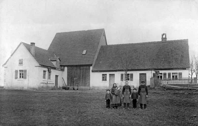 Family of Farmers Posing in Front of the Farm