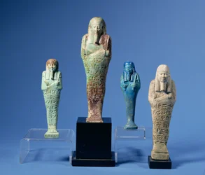 Four green or blue glazed Shabti figures, three with horizontal bands of hieroglyphic inscription, Egyptian