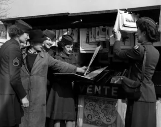 Second World War (1939-1945): Paris (France) March 1945: Four Wacs (Women Army Corps) of the US Army discuss with a book player on the banks of the Seine.