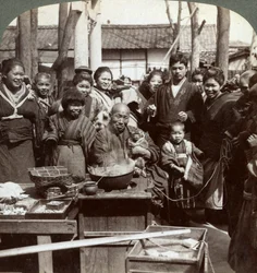 A street performer with a monkey amusing the crowd, Kobe, Japan, 1896