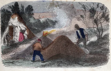 Manufacture of charcoal in the 19th century: coal makers in front of millstones composed of wood and clay logs to which they set fire. Engraving late 19th century