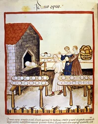 Black bread: a baker at work in front of an oven. Illumination from the book of medicine and dietetics, “Tacuinum sanitatis”.