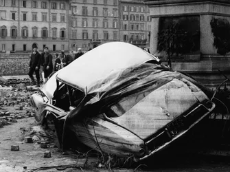 Citroen DS flung up against a monument during the flood of Florence, November 1966