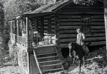 Woman, possible healthcare worker, on horseback visits with neighbors or family