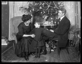 Dan Seymour and family in informal pose, seated beneath a Christmas tree, Christmas 1912