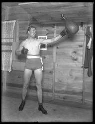 English Boxer William Thomas Wells (Bombardier Billy Wells), Posing in Training Togs with a Speed Bag