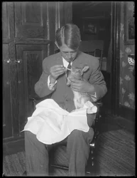 James H. Hassler feeding a rabbit, c.1912