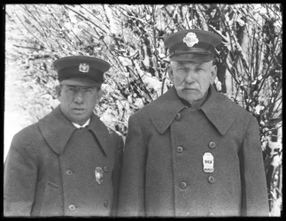Larry Casey and John Connolly posed in their winter uniforms in the snow, Isham Park, Inwood, New York City, March 7, 1915