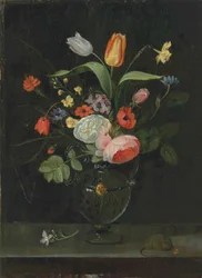 Roses, tulips, a daffodil and other flowers in a glass vase, on a stone ledge with a mouse